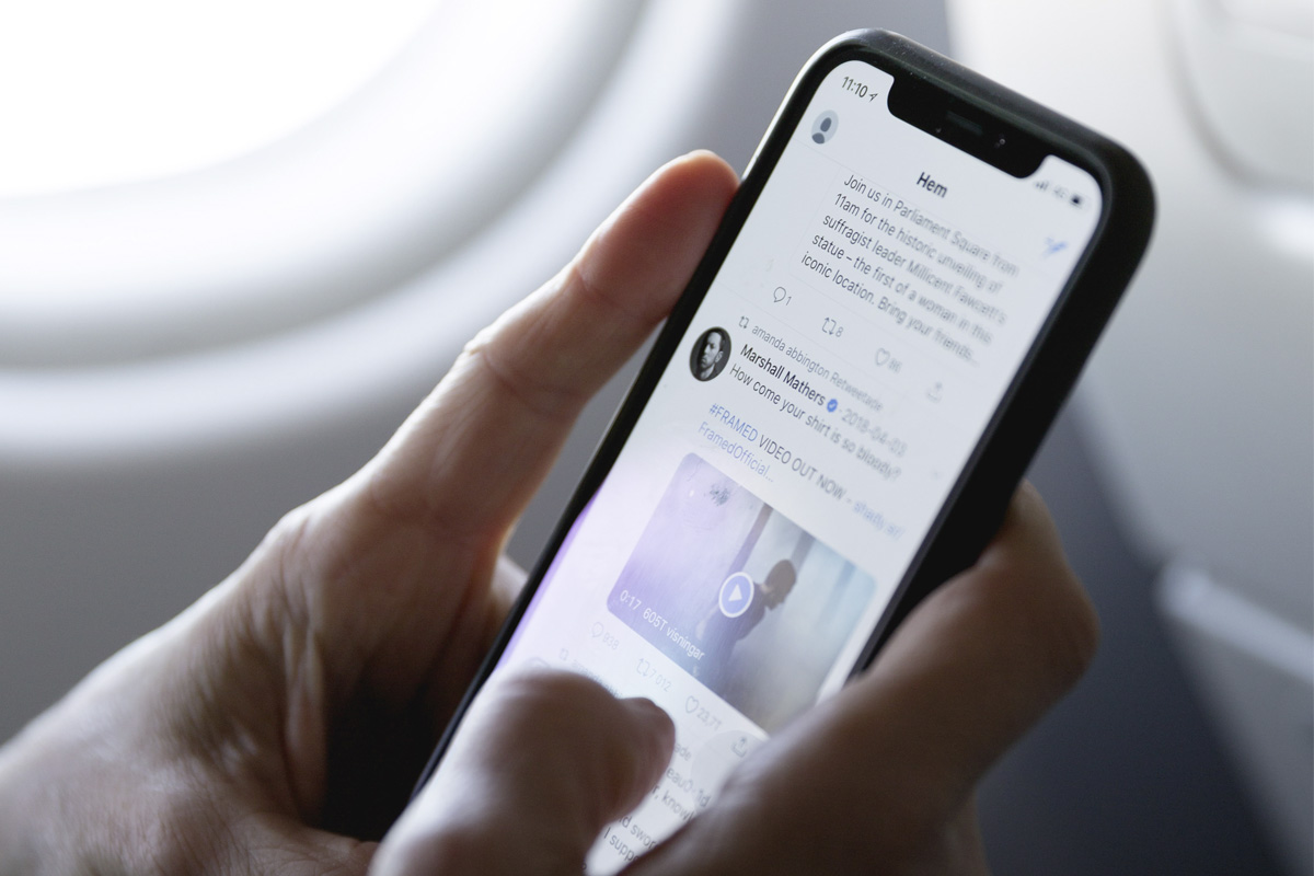Eine Person scrollt auf einem Smartphone auf Twitter.