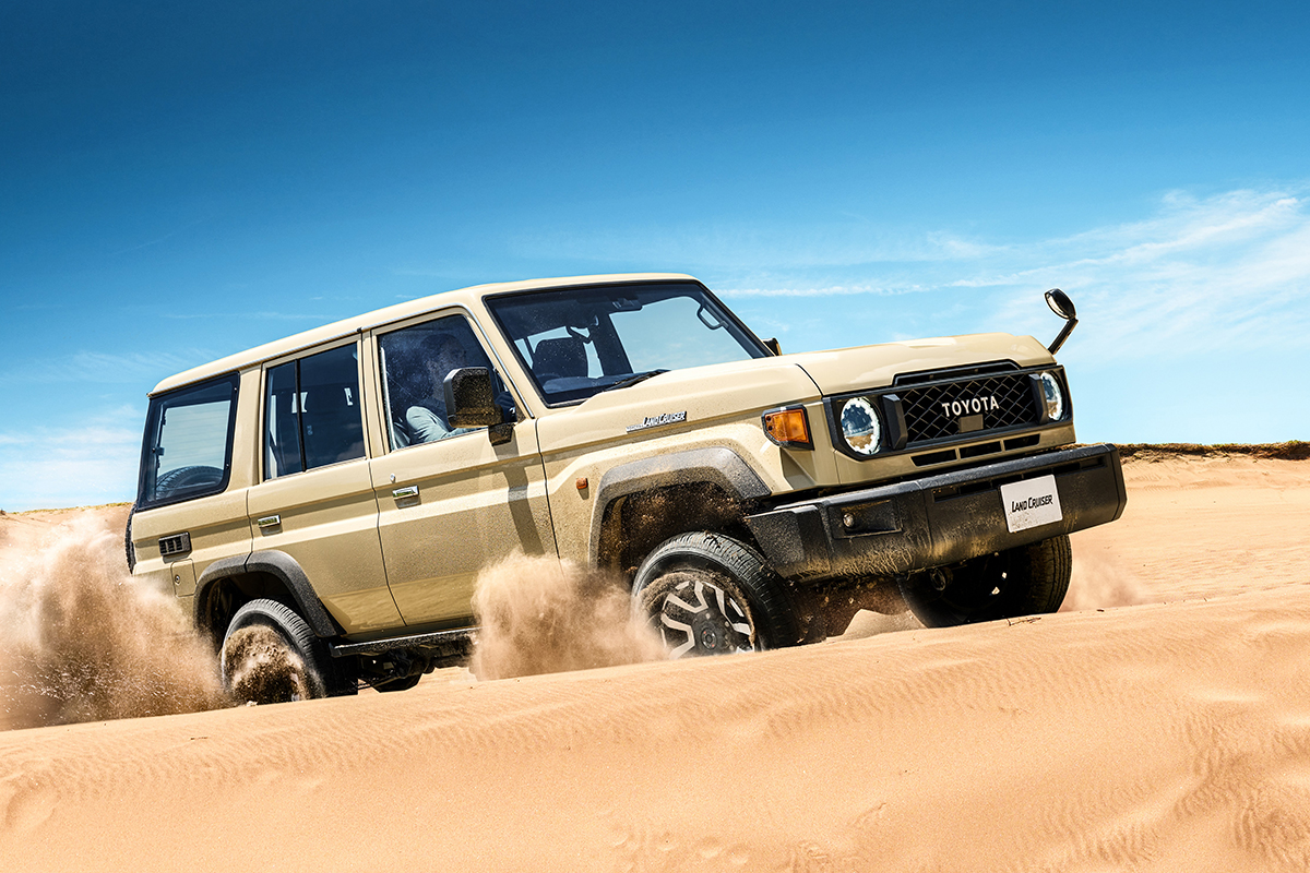 Das Facelift des neuen Land Cruiser 70 in der Wüste, vor blauem Himmel fotografiert.