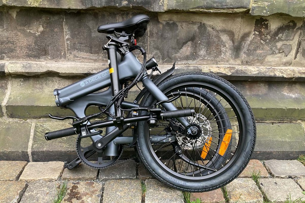 Zusammengefaltetes E-Bike leht vor einem Gemäuer