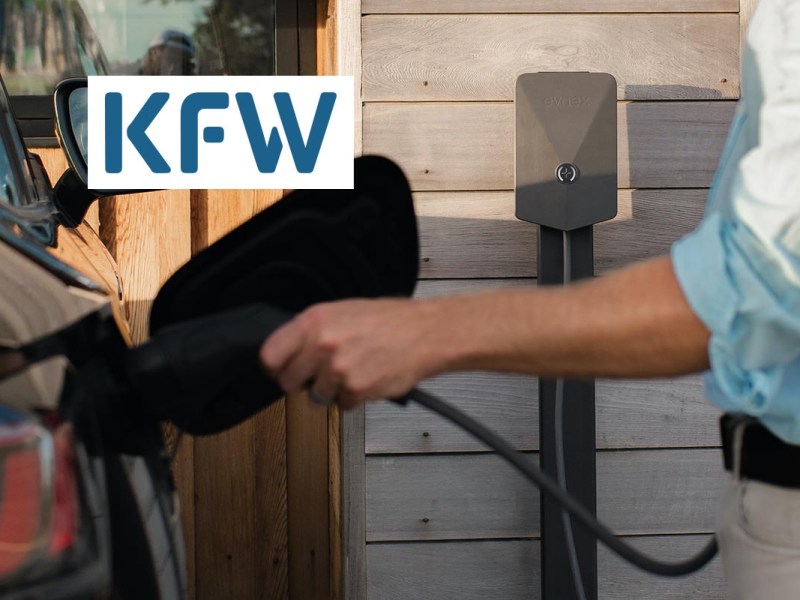 Eine Person lädt ihr Elektroauto auf. In der oberen Ecke des Bildes ist das Logo der KfW.