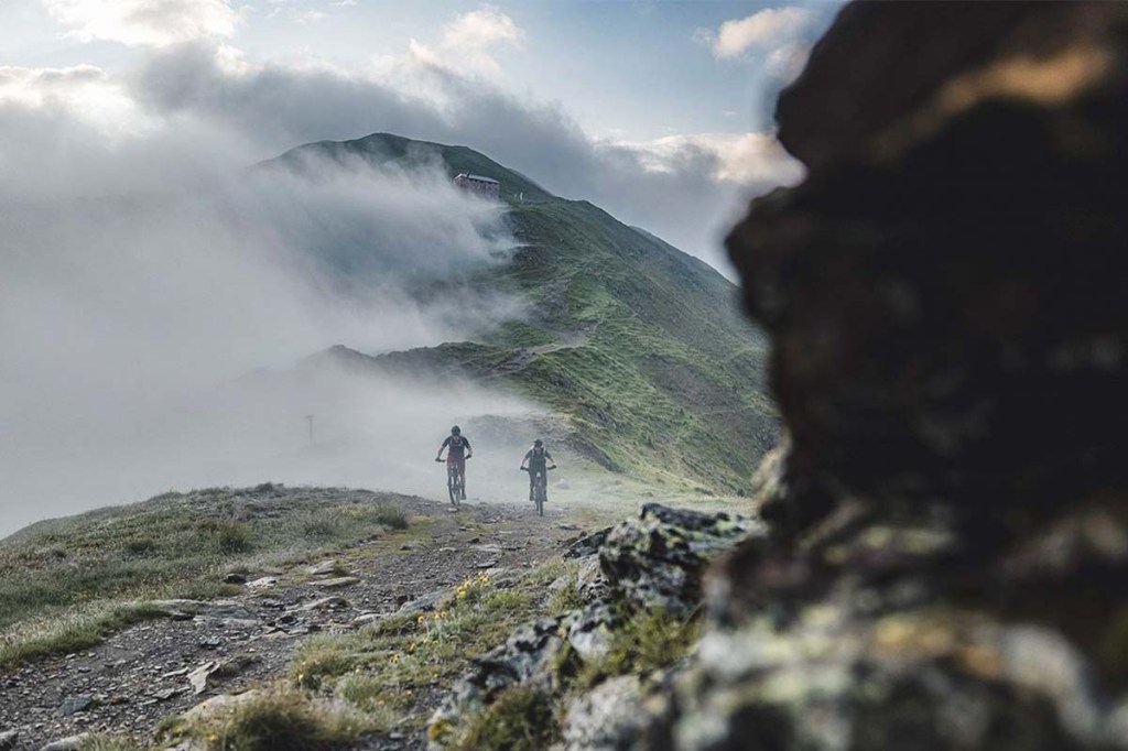 Zwei E-Mountainbikefahrher inmitten einer Bergkulisse fahrend