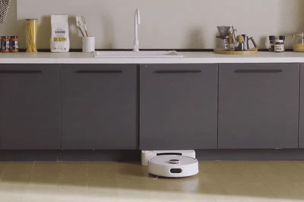 Der neue SwitchBot Saug-Wisch-Roboter an der Wasserstation in einer Küche.