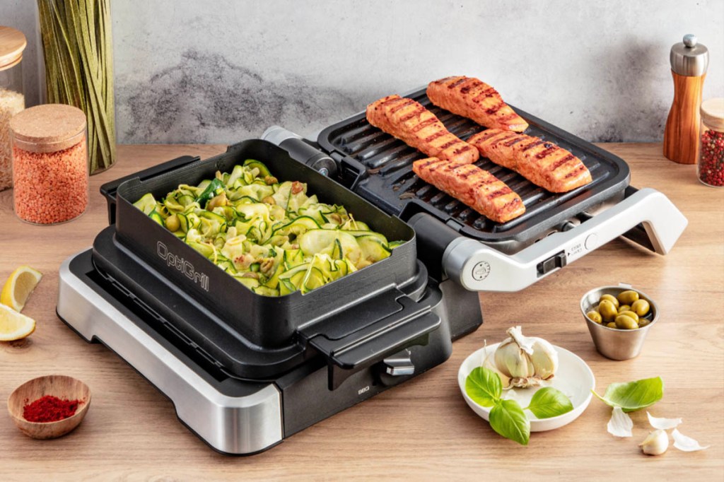 Der aufgeklappte Tefal-Kontaktgrill mit Lachfilets rechts und einer Bratschale mit Gemüse links.