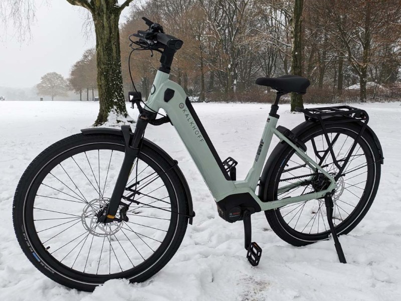 weißes E-Bike in einem verschneiten Park stehend