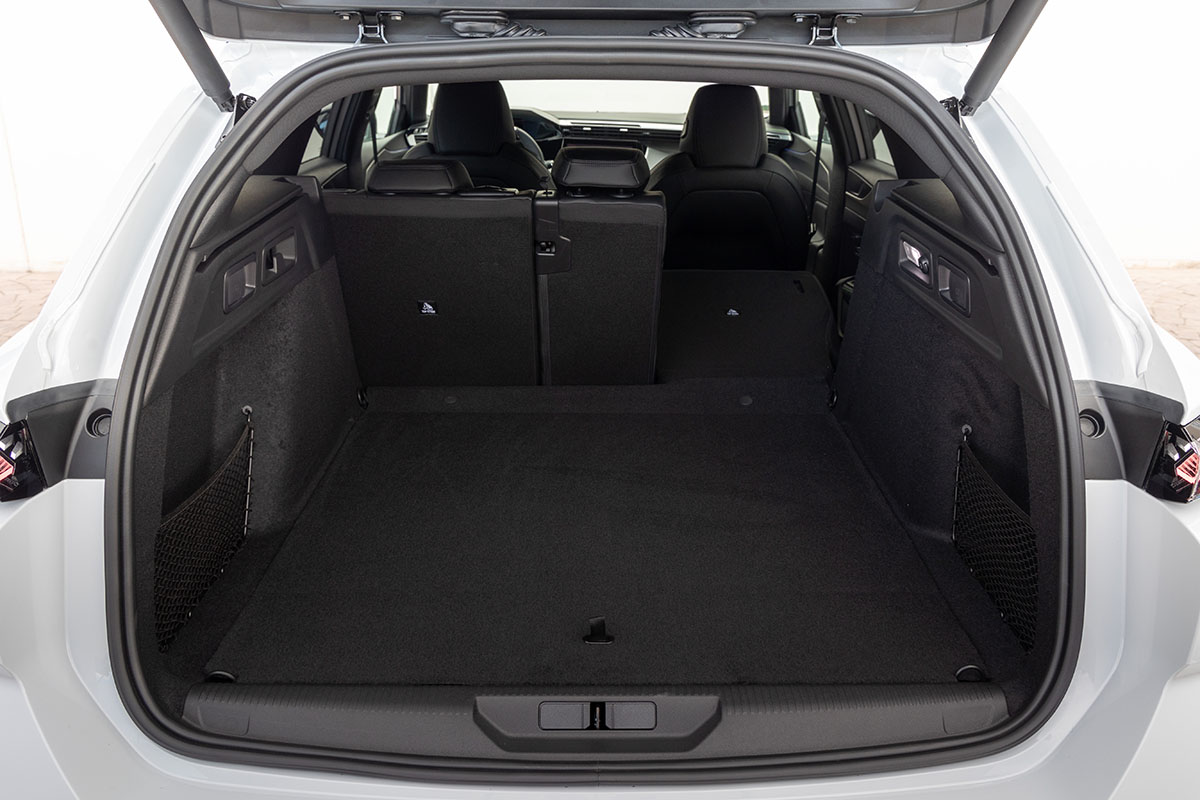 E-Auto Kombi Peugeot E-308 SW mit geöffneter Kofferraumklappe und umgeklappten Rücksitzen.