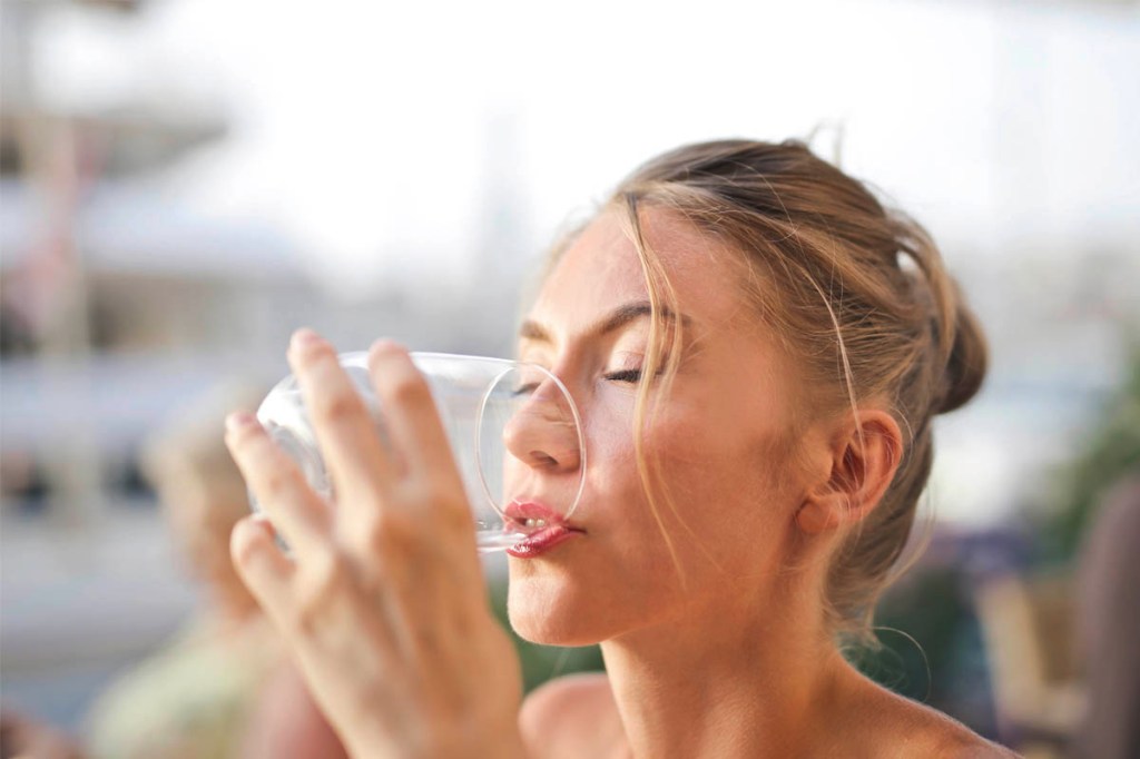 Eine Frau trinkt Wasser aus einem Glas