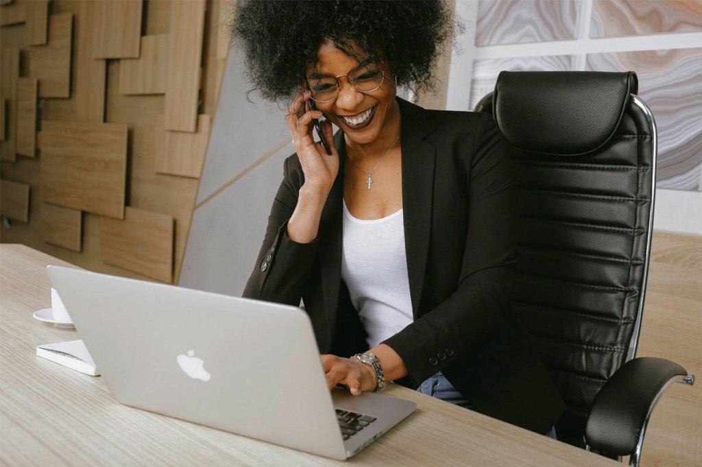 Eine Frau telefoniert, vor ihr steht ein MacBook.