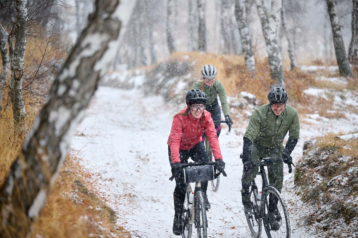 Drei Radfahrer fahren durch eine winterliche Landschaft