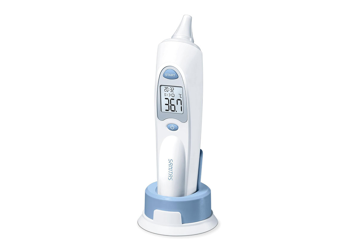 Ohrthermometer von Sanitas stehend in Halterung mit eingeschalteten Display vor weißem Hintergrund.