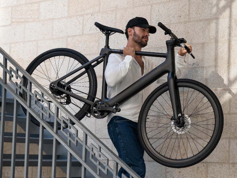 Mann trägt sein E-Bike eine Treppe runter