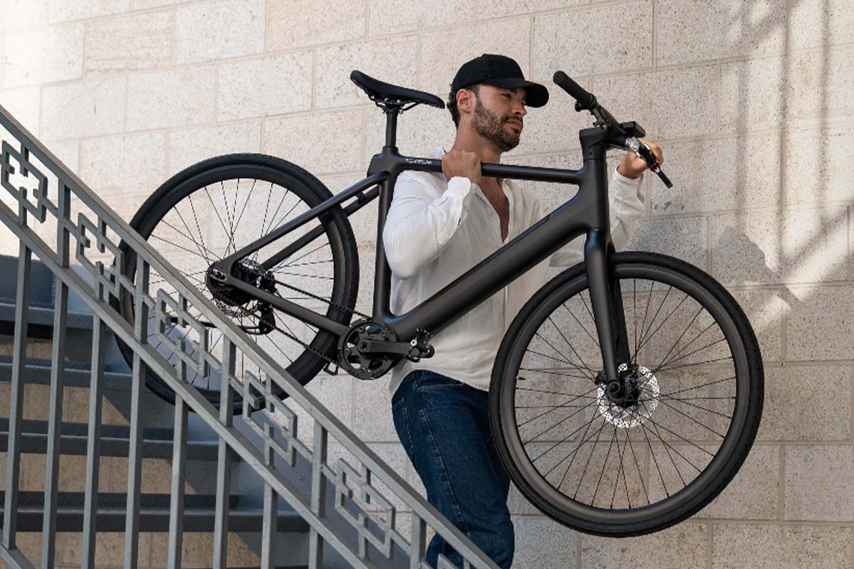 Mann trägt sein E-Bike eine Treppe runter