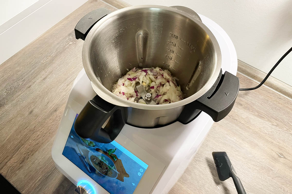 Geschnittene Zwiebeln und Knoblauchzehen im Mixtopf des Monsieur Cuisine Smart.