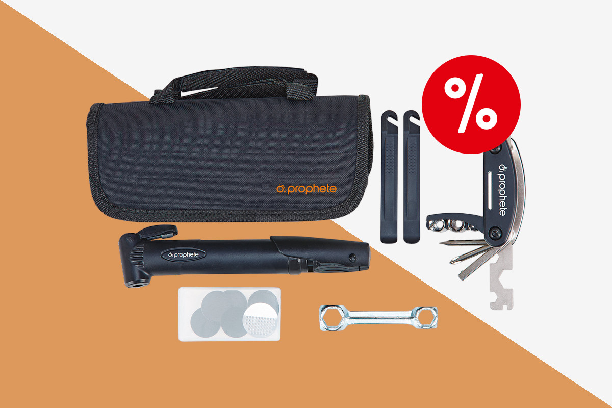 Fahrradwerkzeug Set bestehend aus schwarzer länglicher Tasche oben links, dadrunter einer schwarzen Miniluftpumpe, daneben zwei schwarze längliche Werkzeuge und ein aufgefächertes Multitool mit rotem Prozentbutton oben rechts auf orange weißem Hintergrund