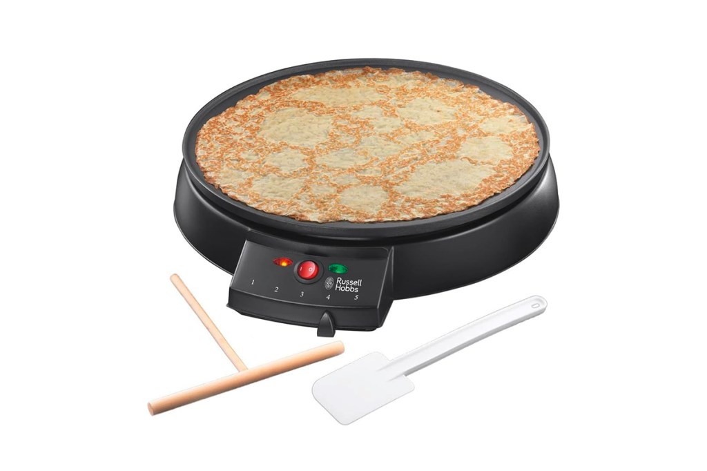 Crepe Maker der Firma Russell Hobbs, mit Zubehör. Vor weißem Hintergrund.