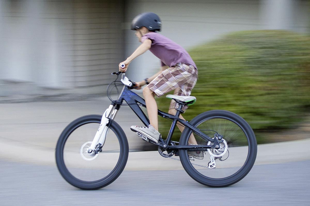 Junge auf einem Fahrrad auf der Straße.