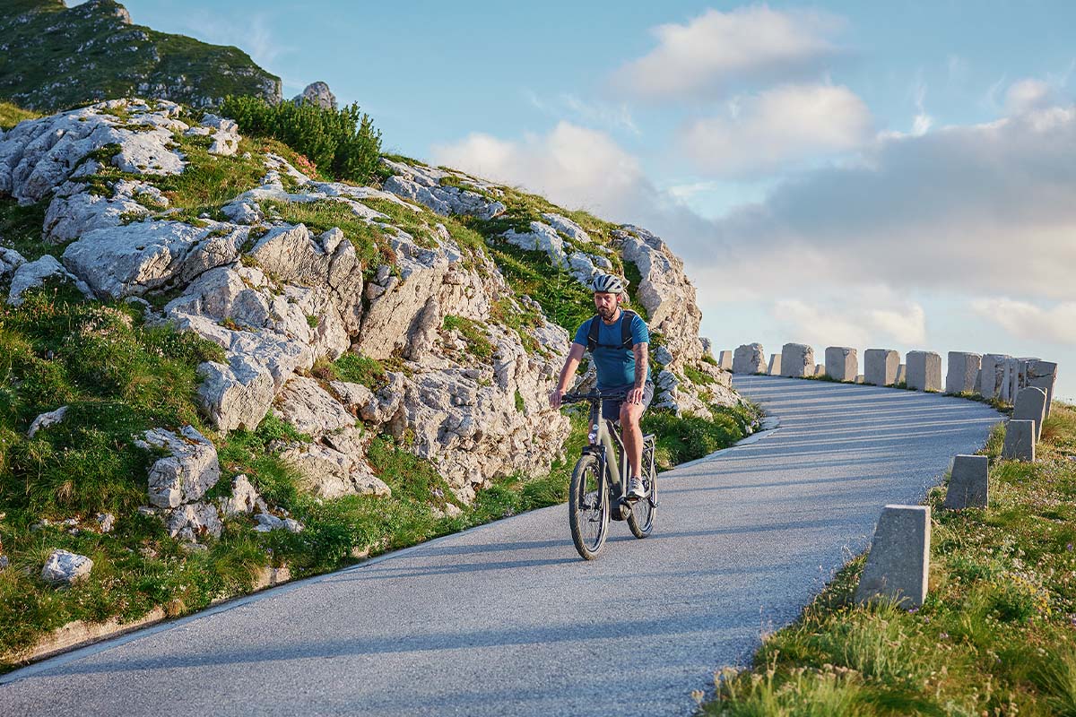 Mann fährt mit einem E-bike eine Serpentinstraße entlang