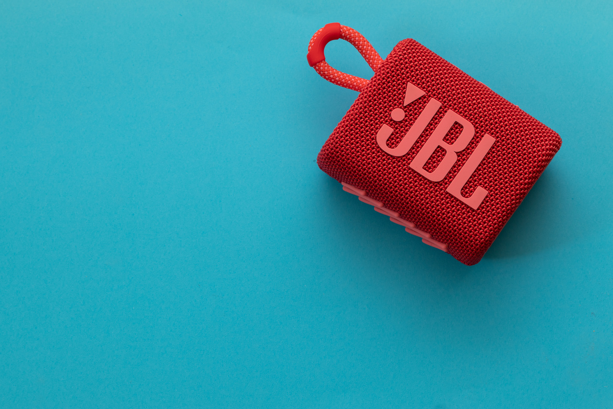 Die rote JBL Go 3 vor blauem HIntergrund.