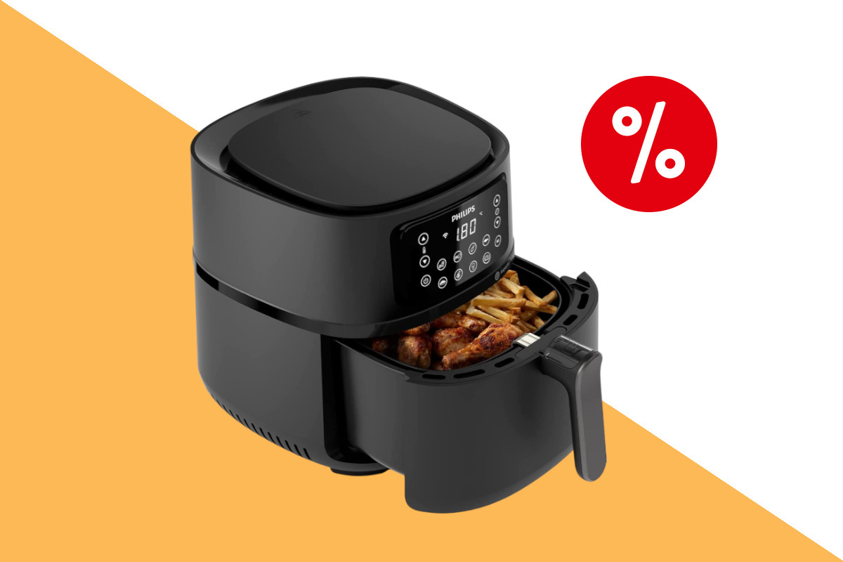 Schwarze Heißluftfritteuse Philips Airfryer XXL schräg von vorne mit geöffnetem Korb in dem Pommes und Hähnchenteile zu sehen sind auf orange weißem Hintergrund mit rotem Prozentbutton oben rechts