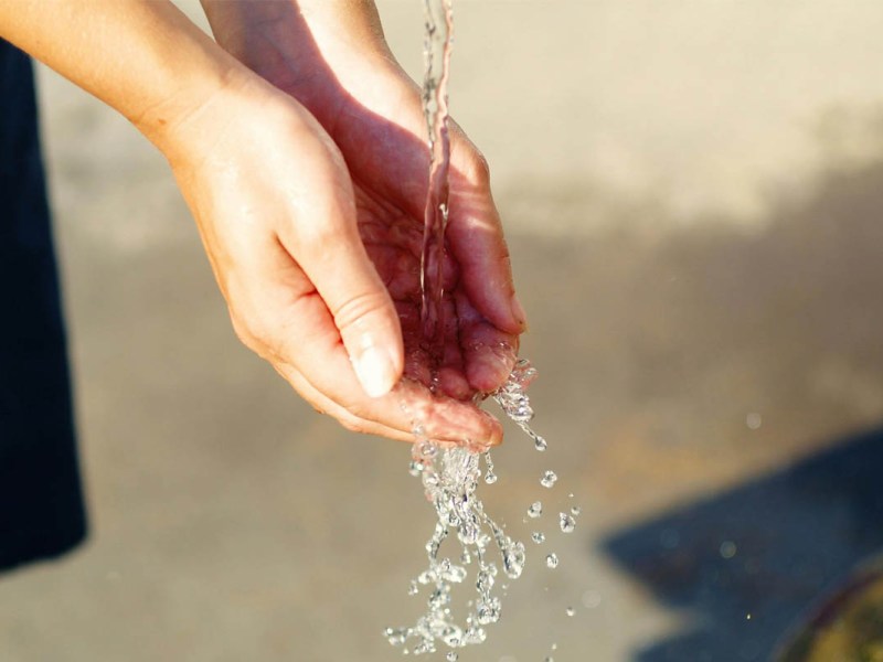 Zwei Hände fangen Wasser auf.