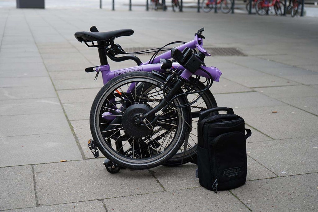 zusammengefaltetes Fahrrad steht auf einem Gehweg