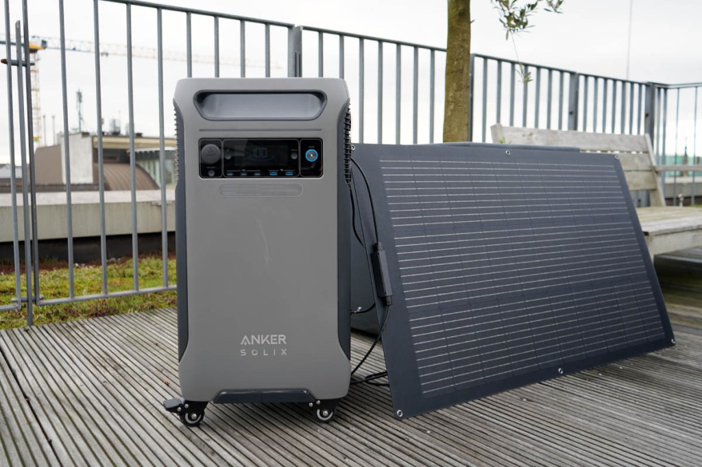 Die Anker Solix F3800 auf einer Terrasse mit Solarpanel an einem Blumentopf.