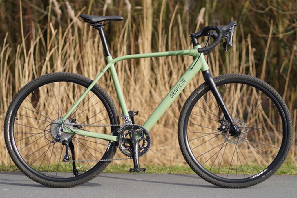 Grünes Gravelbike auf einem Weg stehend, Natur im Hintergrund