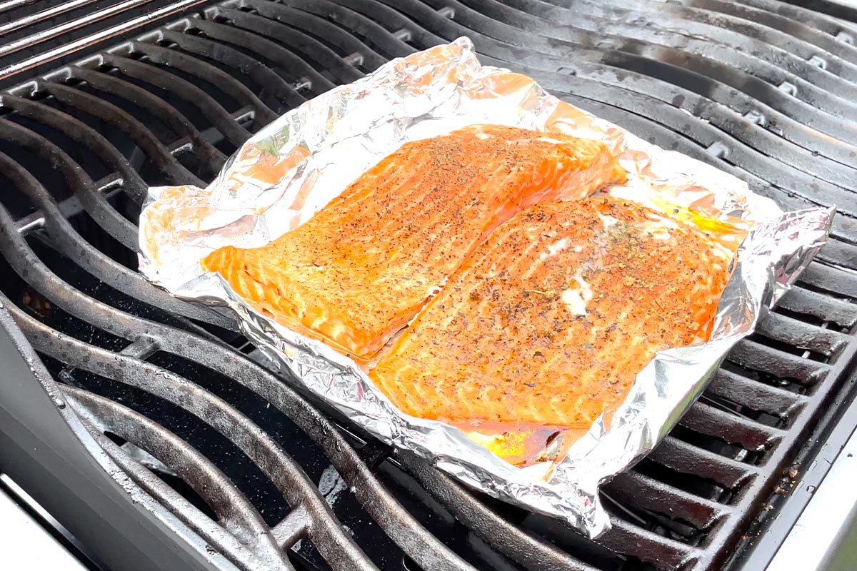 Lachs in Alufolie auf einem Gasgrill.