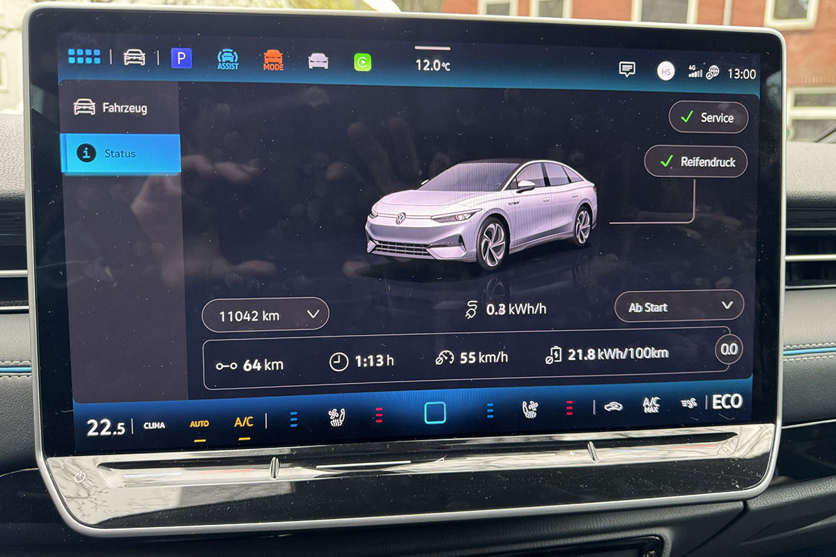 Detailaufnahme des Infotainment-Displays im VW ID.7 mit Anzeige für für Fahrzeugdaten wie Gesamtkilometer, durchschnittlicher Verbrauch, Reifendruck.