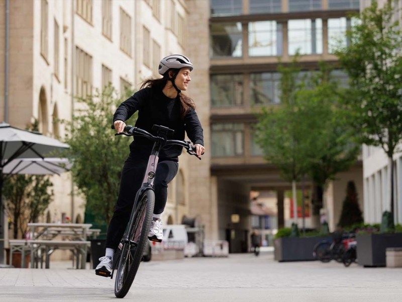 Frau fährt mit einem Fahrrad durch die Stadt