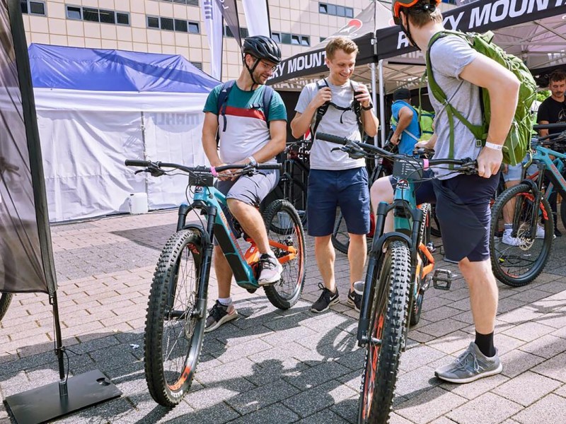 Mehrere Personen auf und an einem E-Bike sitzend und stehend.