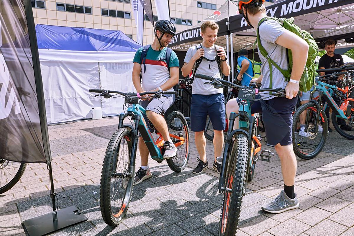 Mehrere Personen auf und an einem E-Bike sitzend und stehend.