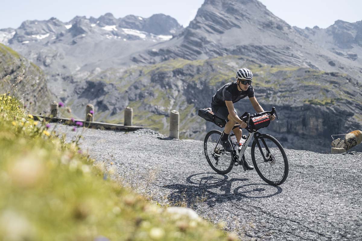 Person fährt mit einem Gravelbike durch eine Naturlandschaft in den BErgen