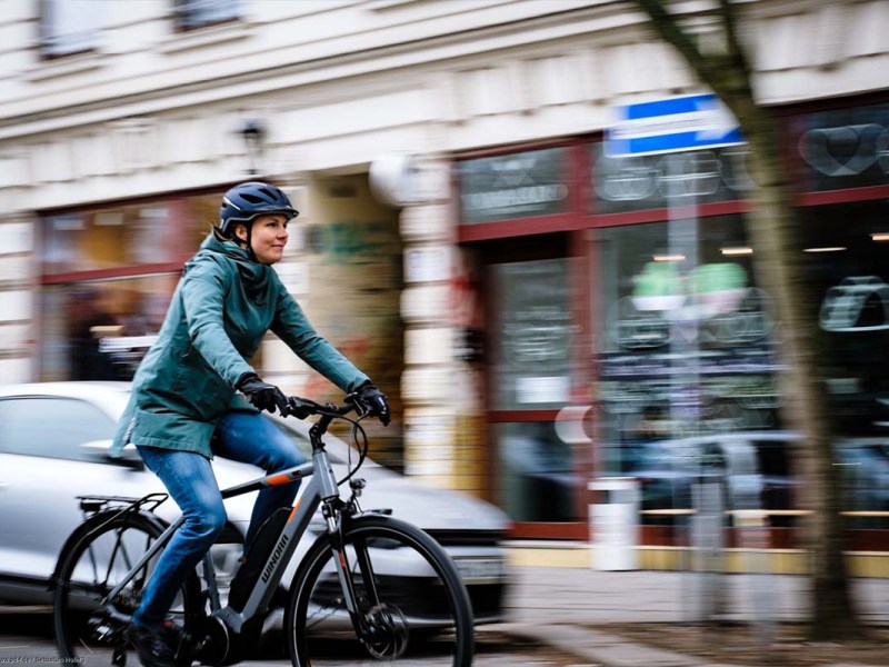 Frau fährt mit einem Fahrrad durch die Stadt