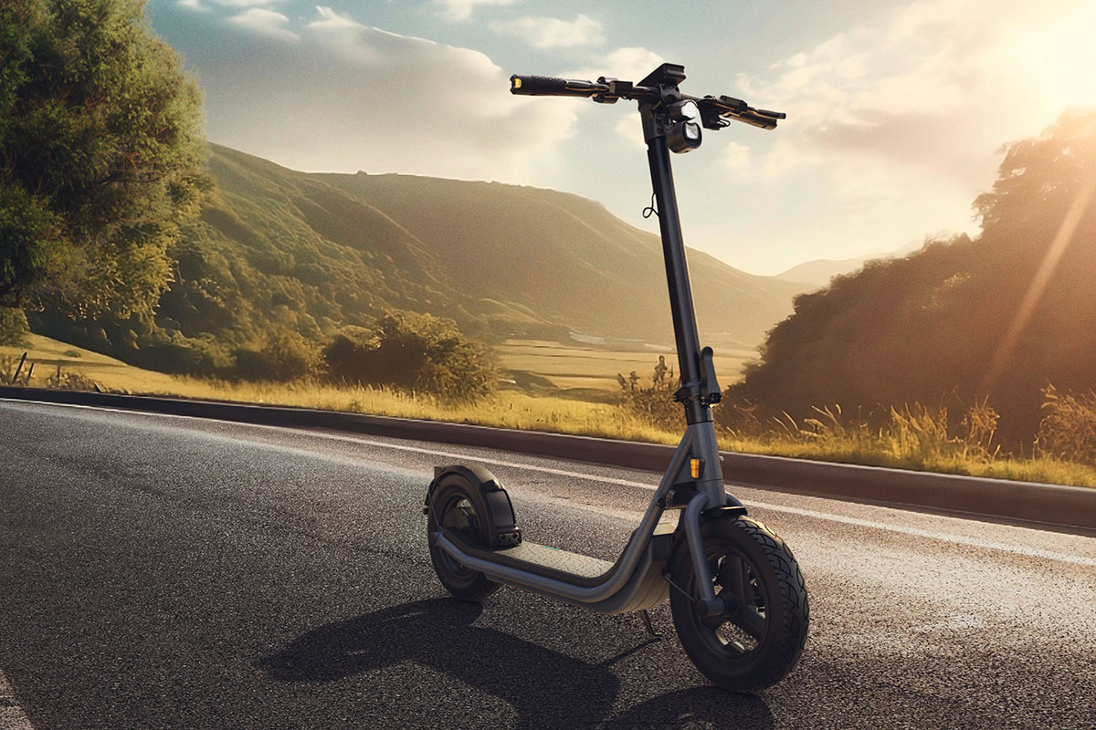 E-Scooter vor bergiger Landschaft im Abendlicht.