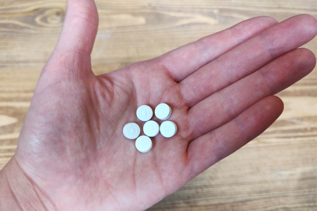 In einer Hand liegen sechs Zahnputztabletten