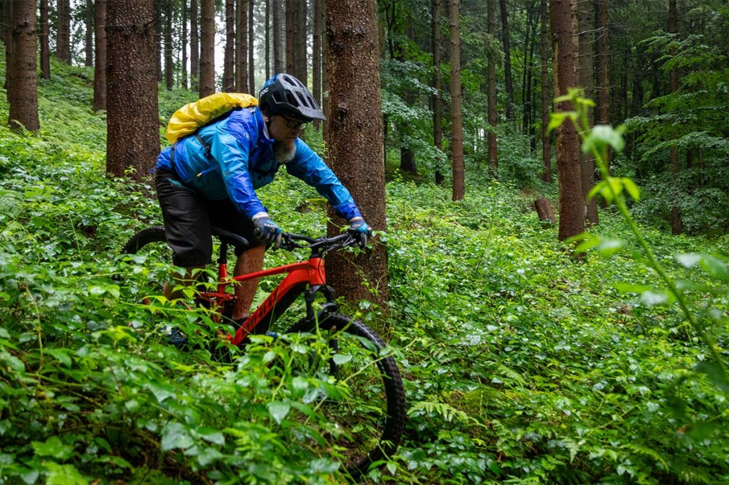 Mann fährt mit einem Mountainbike durch den Wald