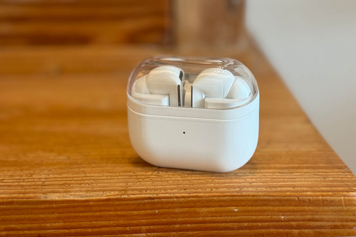 Galaxy Buds 3 Pro in weißem Case auf einem Holztisch