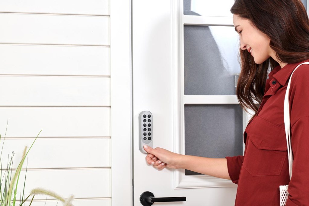 Das Keypad des Smart Lock U200 von Aqara wird von einer Frau benutzt.