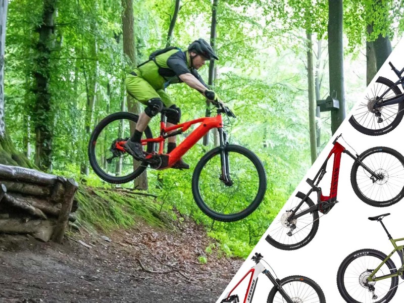 Mann springt mit seinem E-Mountainbike über eine Schanze im Wald