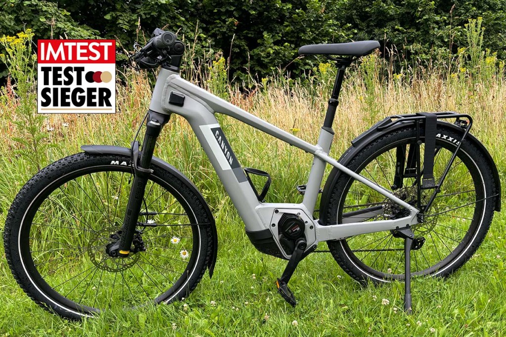 Totale E-Bike auf einer Wiese stehend, mit Testsieger-Grafik