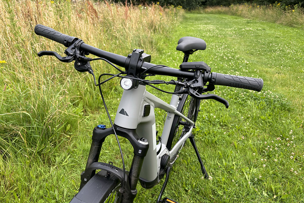 Graues Trekking-E-Bike Canyon Pathlite:ON 6 SUV steht vor einem Weizenfeld am Wegesrand.