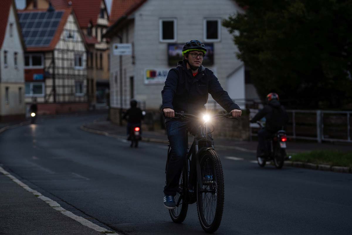 Radfahrer, der in der Dämmerung eine Straße langfährt