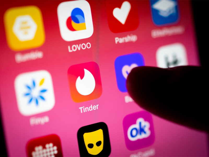 Ein Finger tippt auf die Tinder-App auf dem Smartphone.