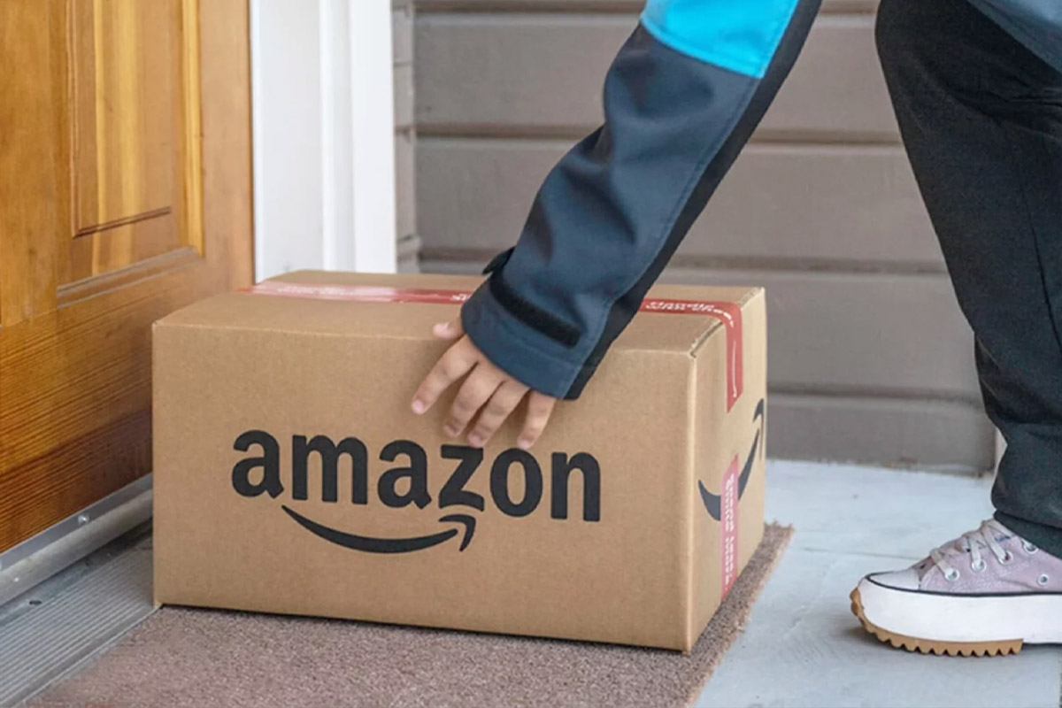 Eine Person legt ein Amazon-Paket auf eine Türmatte.