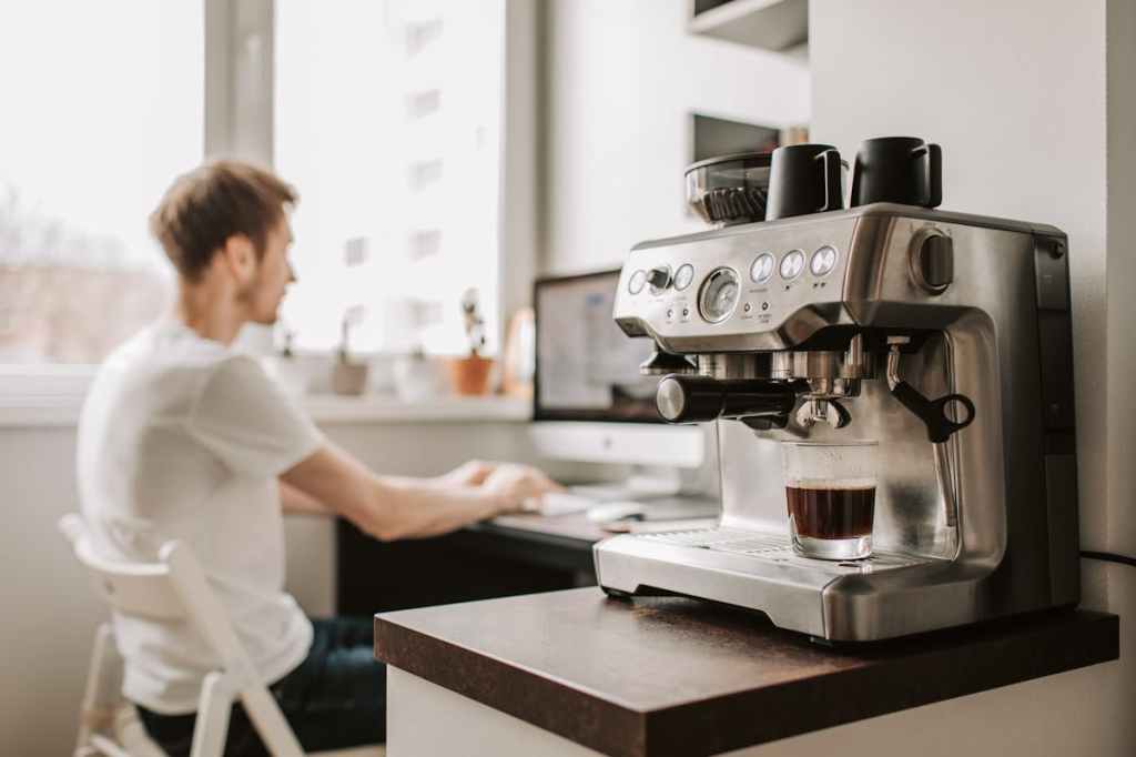 Siebträgermaschine vor Person am Schreibtisch