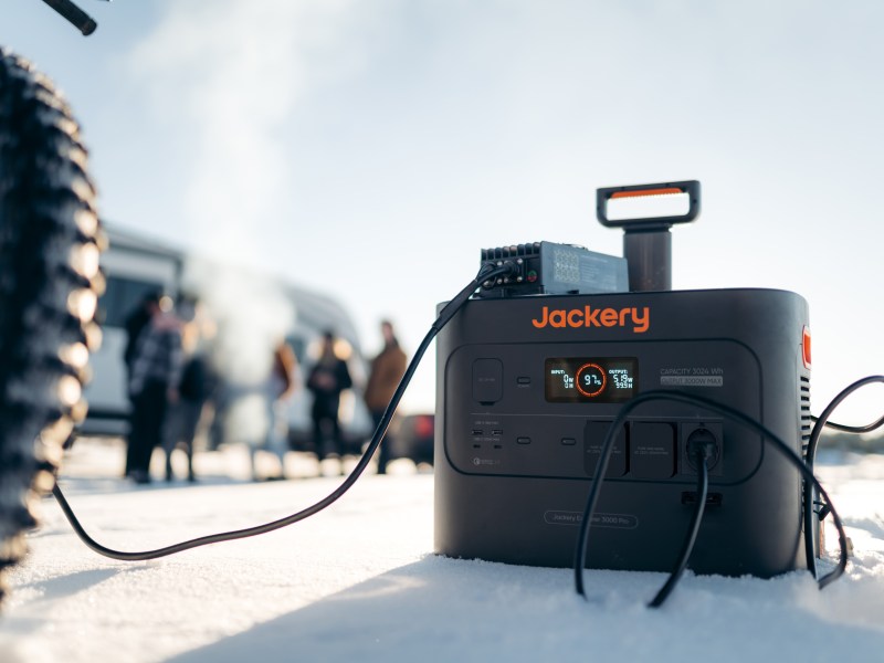 Die Jackery E3000 Pro steht im Schnee. Es ist ein Fahrrad und im Hintergrund Menschen erkennbar.