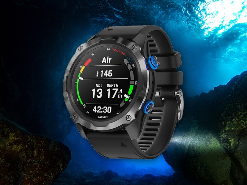 Die schwarze Garmin-Smartwatch Mk2I vor einem Unterwasser-Panorama