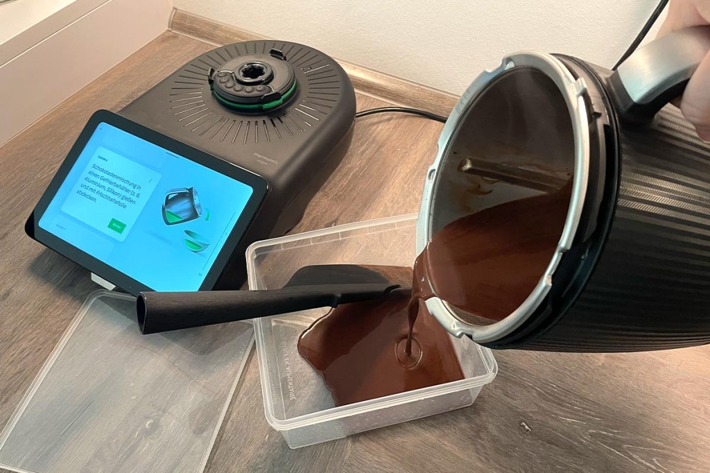 Eine braune Flüssigkeit wird vom Thermomix TM7 Mixtopf in eine durchsichtige, eckige Form gegossen.